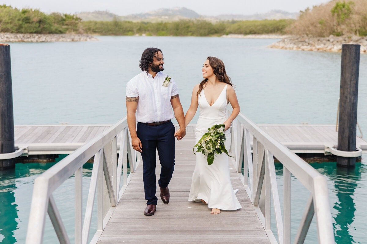 bride and groom walking on bridge