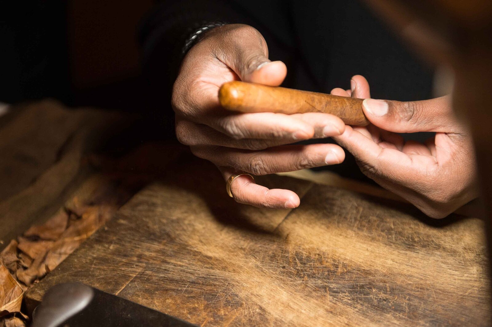 Holiday party details man rolling cigar.-