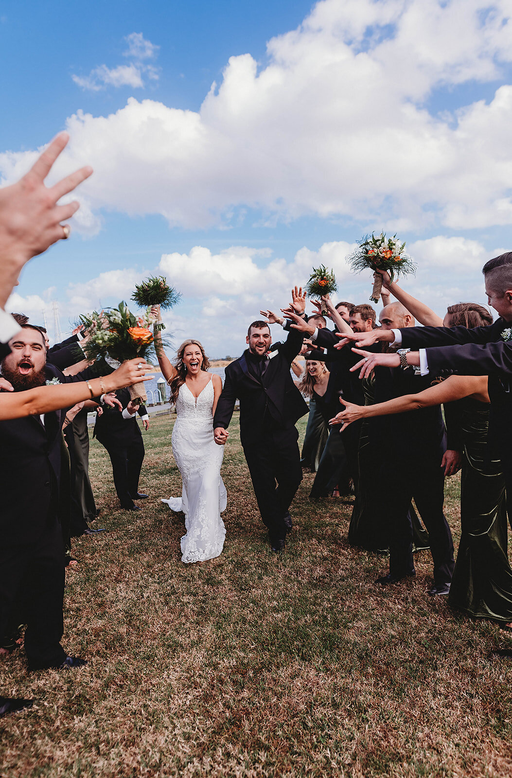 bride and groom walk in between their wedding party being showered in love and happiness