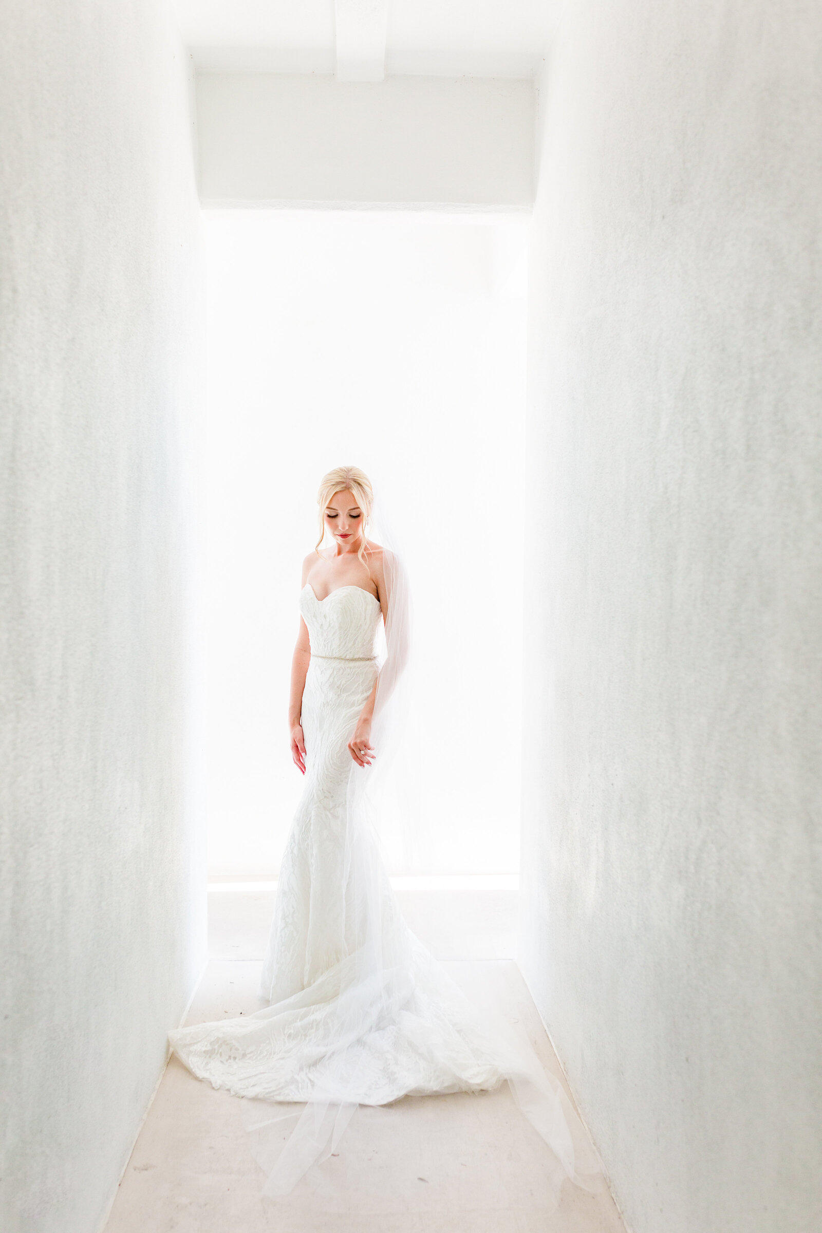 Tampa Wedding photographers capture image of bride in white hallway at venue