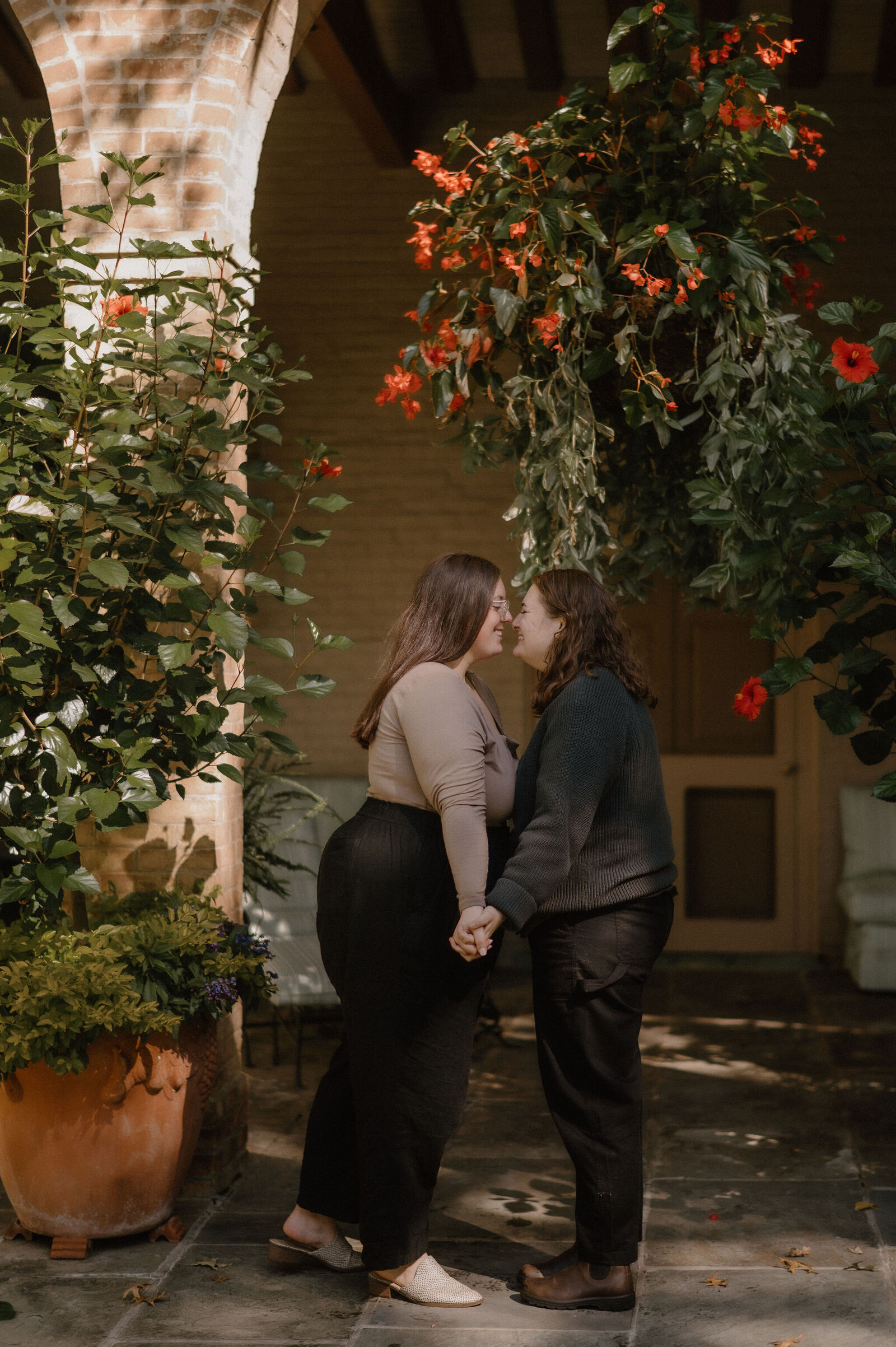 romantic lesbian engagement session with red flowers and bright sun