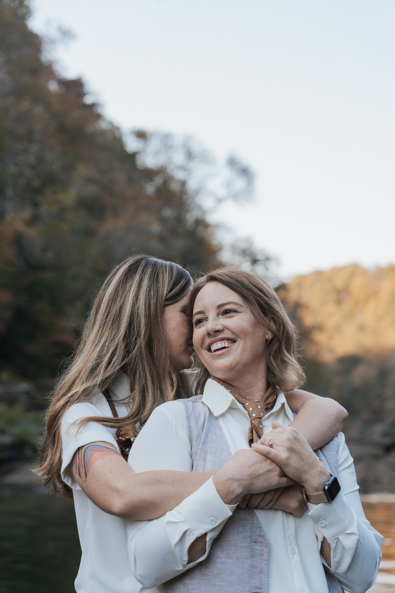 Wife hugs her wife around the shoulders 