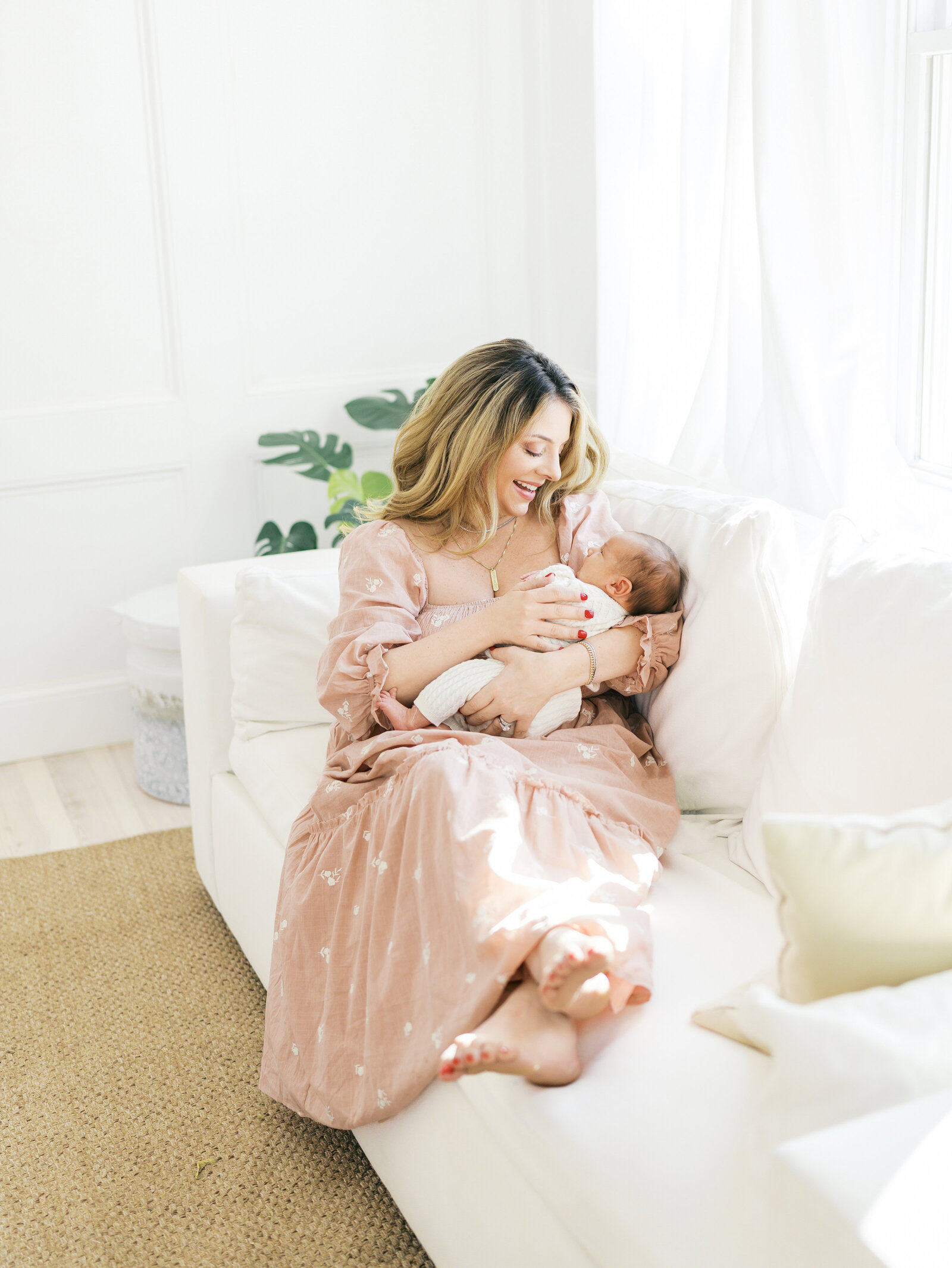 mom holding baby in light and airy studio