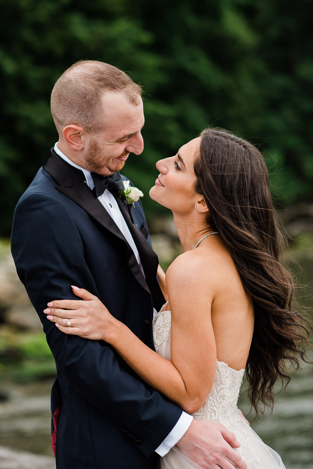 bride and groom look at each other on dock