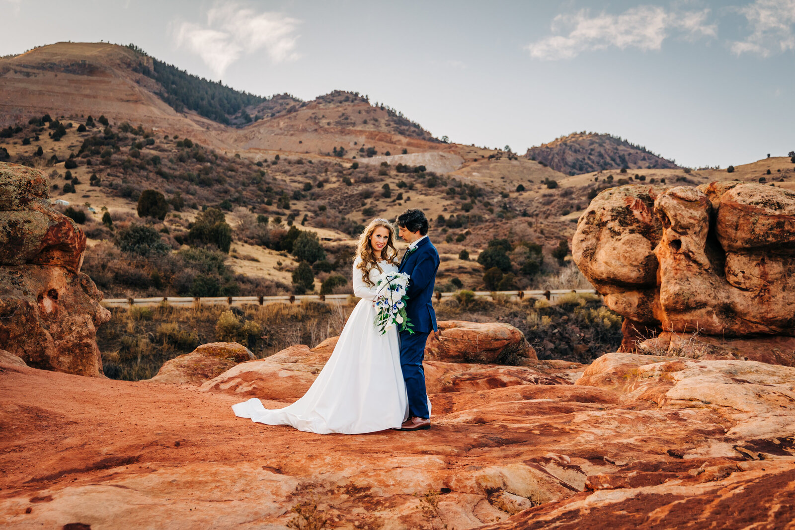 Denver Wedding Photographer captures bride and groom standing together in red rocks