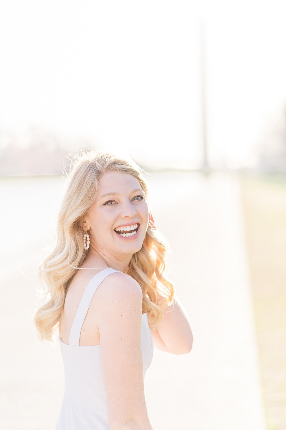 college senior girl laughing by the reflecting pool