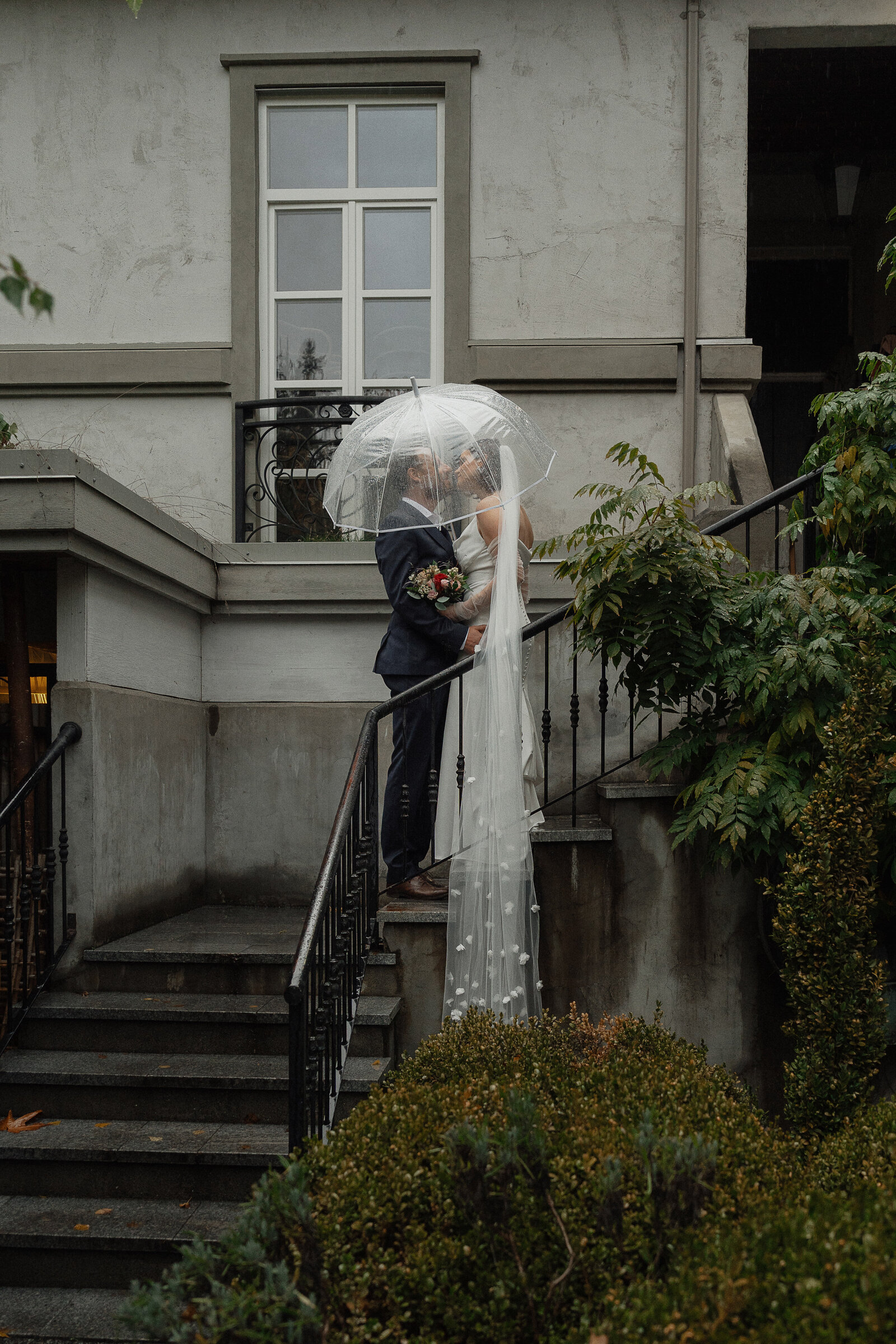 Bride and Groom on the outside stairs at Cuckoo Trattoria and Pizza in Coombs during wedding portraits by Latitude 49 Photography