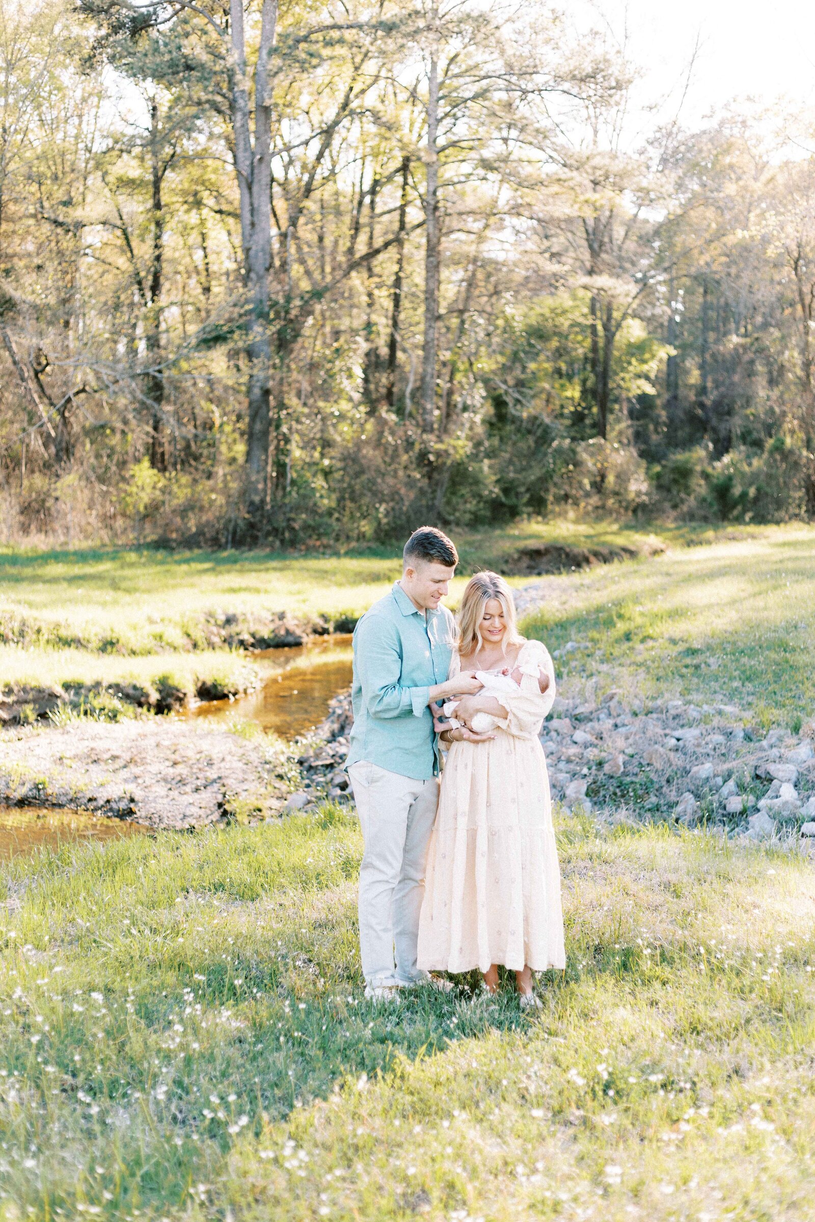 parents standing outside with baby during peoria illinois newborn photos 