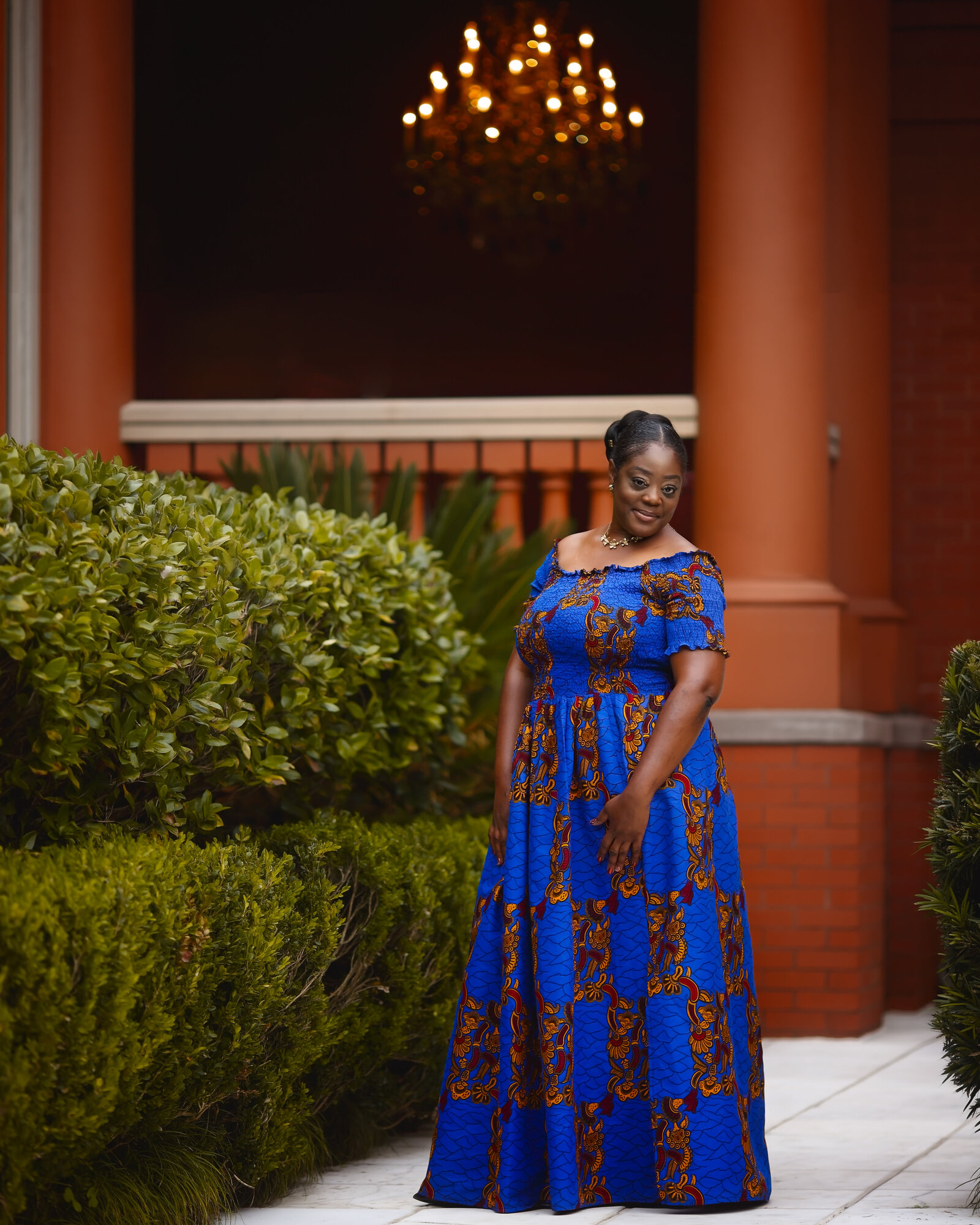 Savannah Boudoir Photography and Glamour showcases gorgeous black woman in african inspired gown in Savannah with chandelier