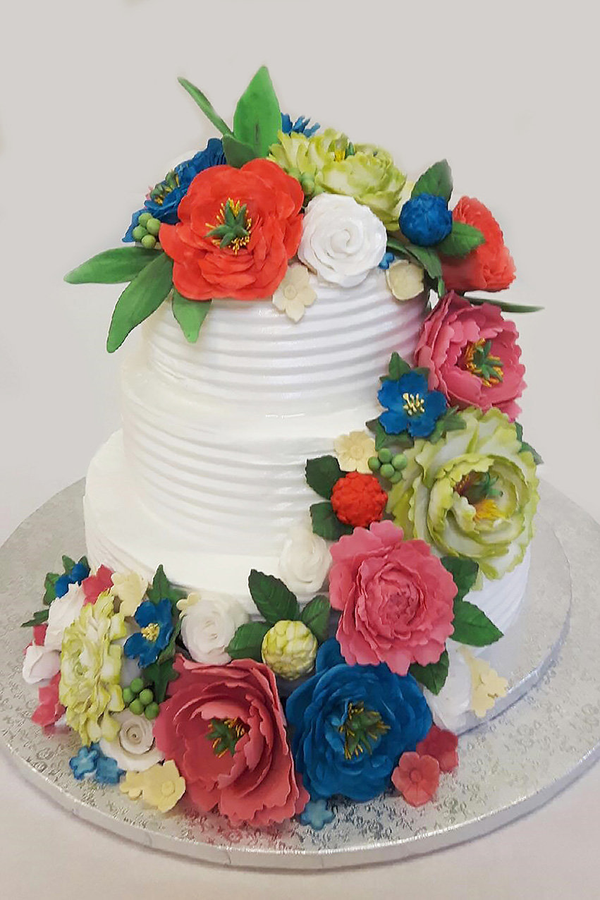 Bruidstaart met gekleurde suikerbloemen van banketbakkerij van den Berg