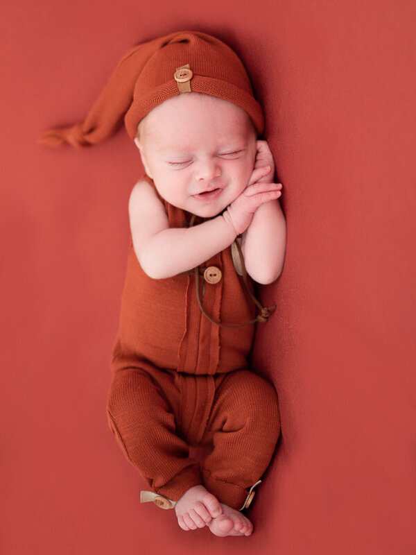East Brunswick NJ Newborn Photographer Orange Romper Baby Smiling