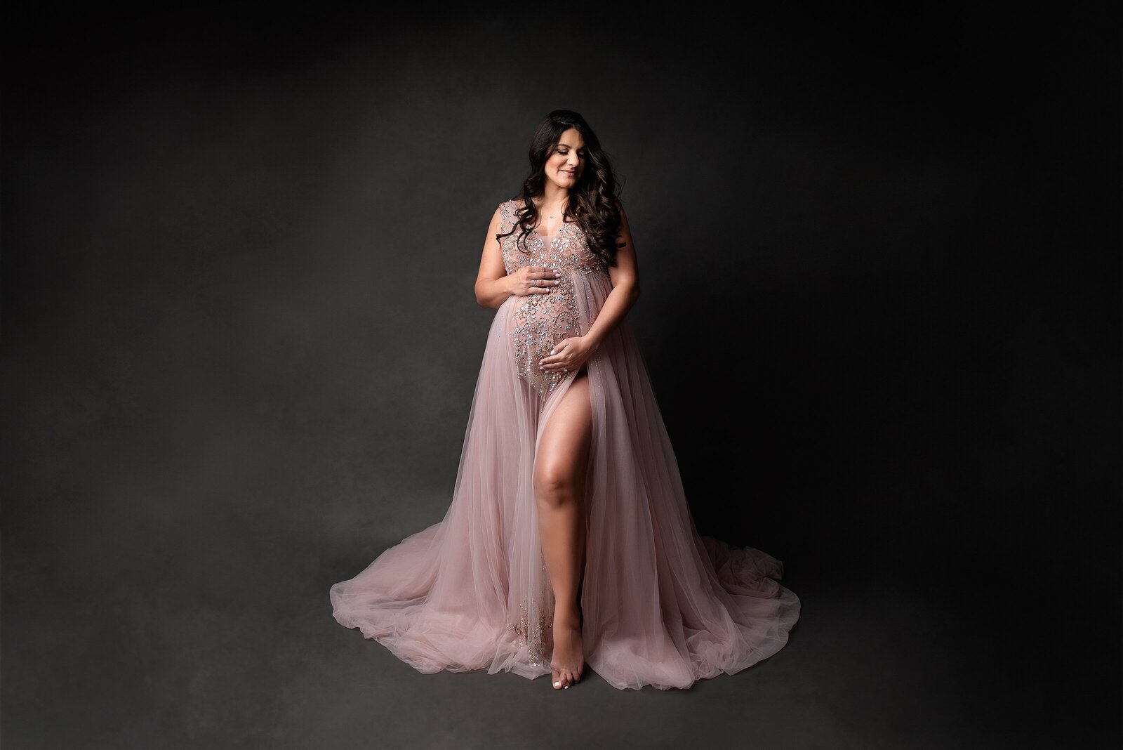 Pregnant mom in pink maternity couture gown posed in West Palm Beach studio.