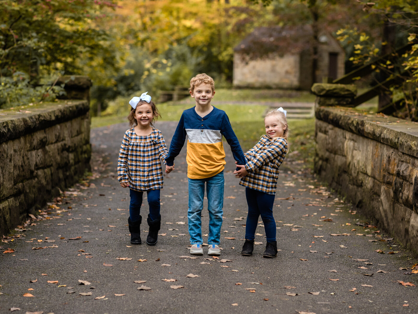 three siblings posing for family photos at david fortier park