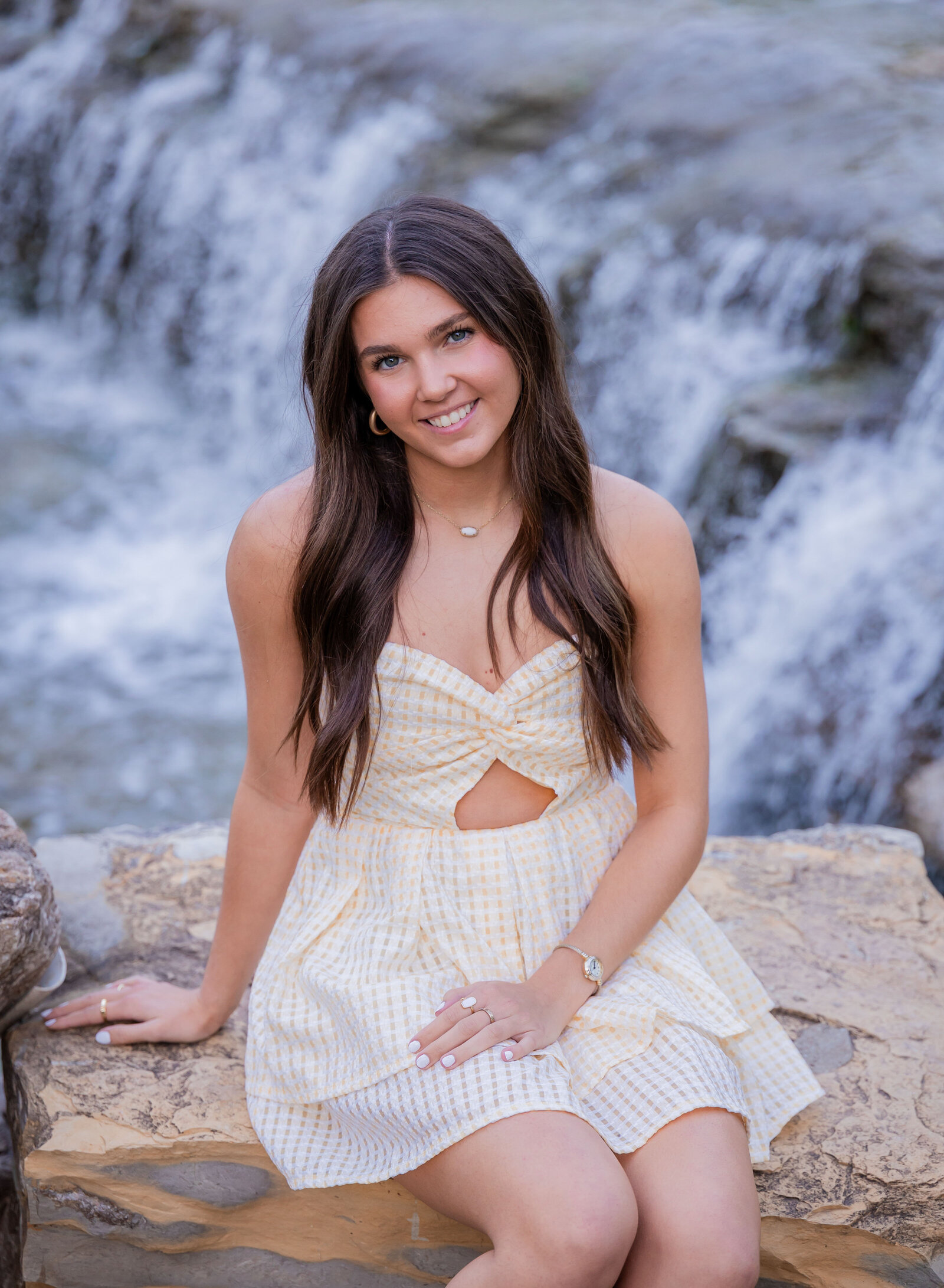 senior portrait of girl in front of a waterfall