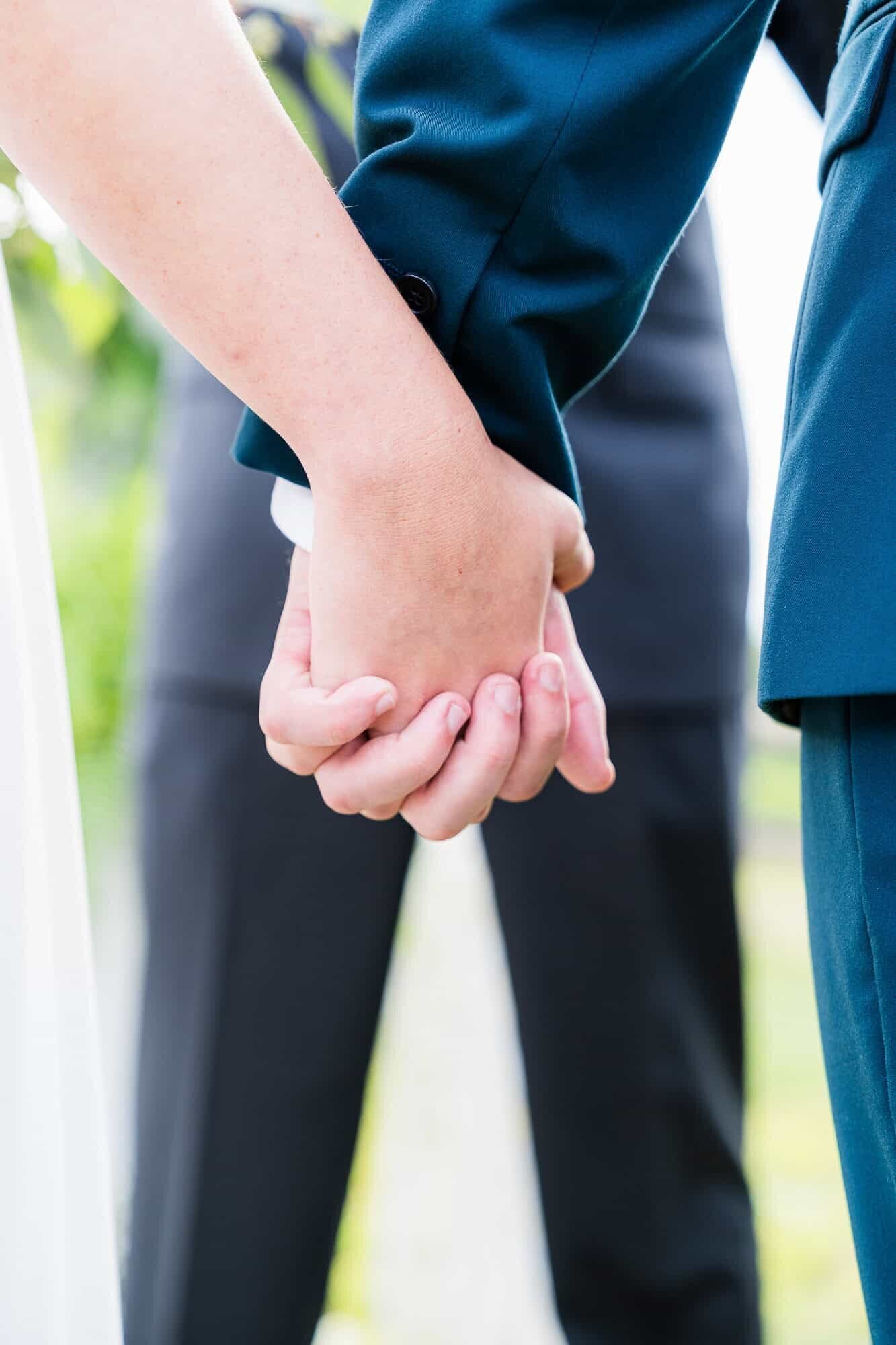 bride and groom holding hands during their wedding ceremony at terra incognita vineyard wedding venue 