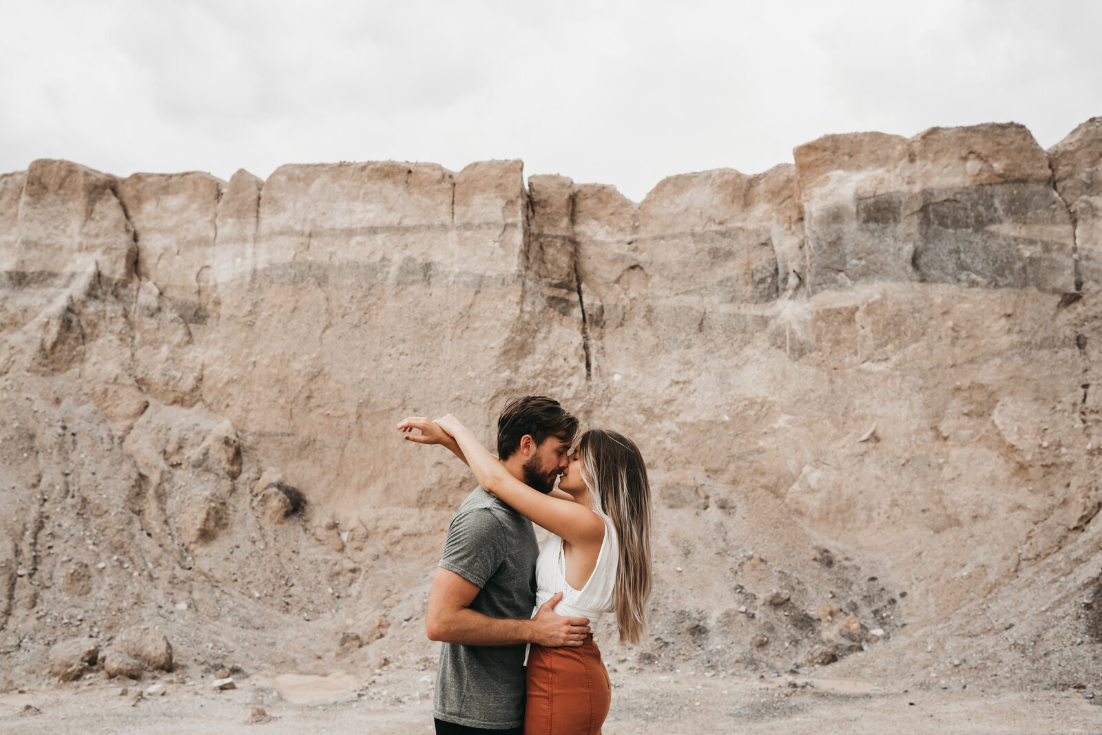 Couple embracing in front of stone rock wall