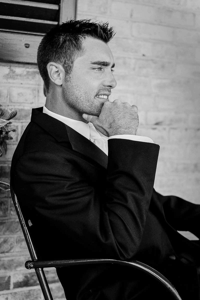Groom poses sitting in chair, Drumore Estate, Pequea, Pennsylvania. Kate Timbers Photography.
