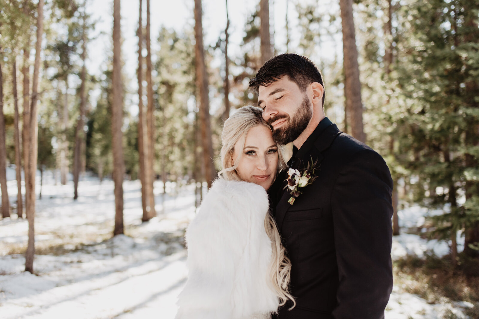 grand teton wedding with bride and groom holding each other in the woods and smiling for their winter elopement captured by Jackson Hole photographers