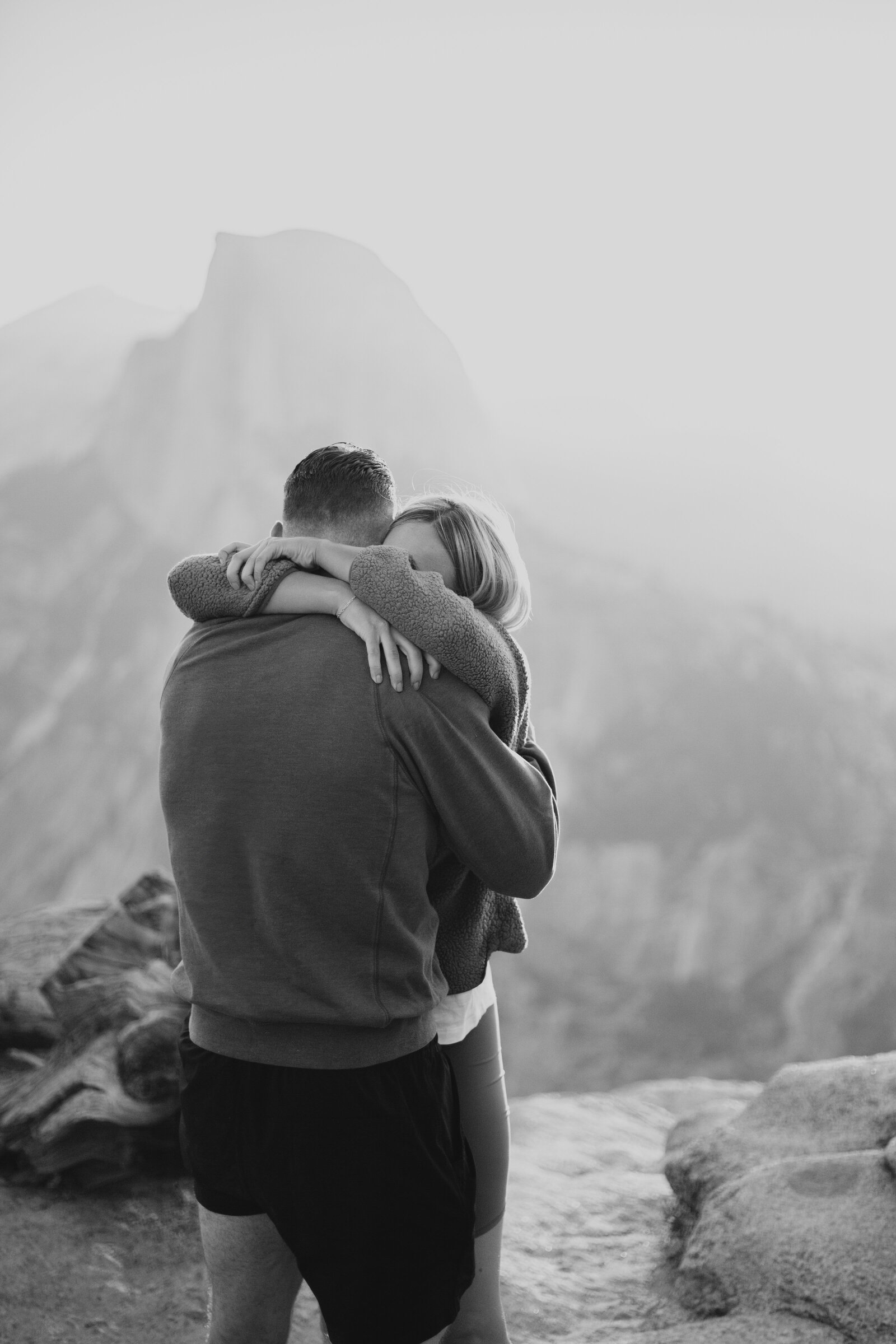 A wedding proposal between two hikers at sunrise in front of Half Dome in Yosemite National Park.