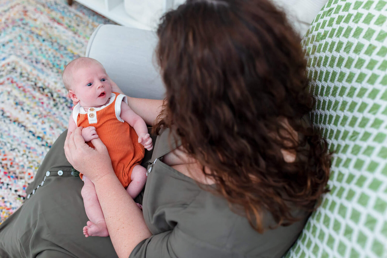 A mom holding her newborn son in her lap.