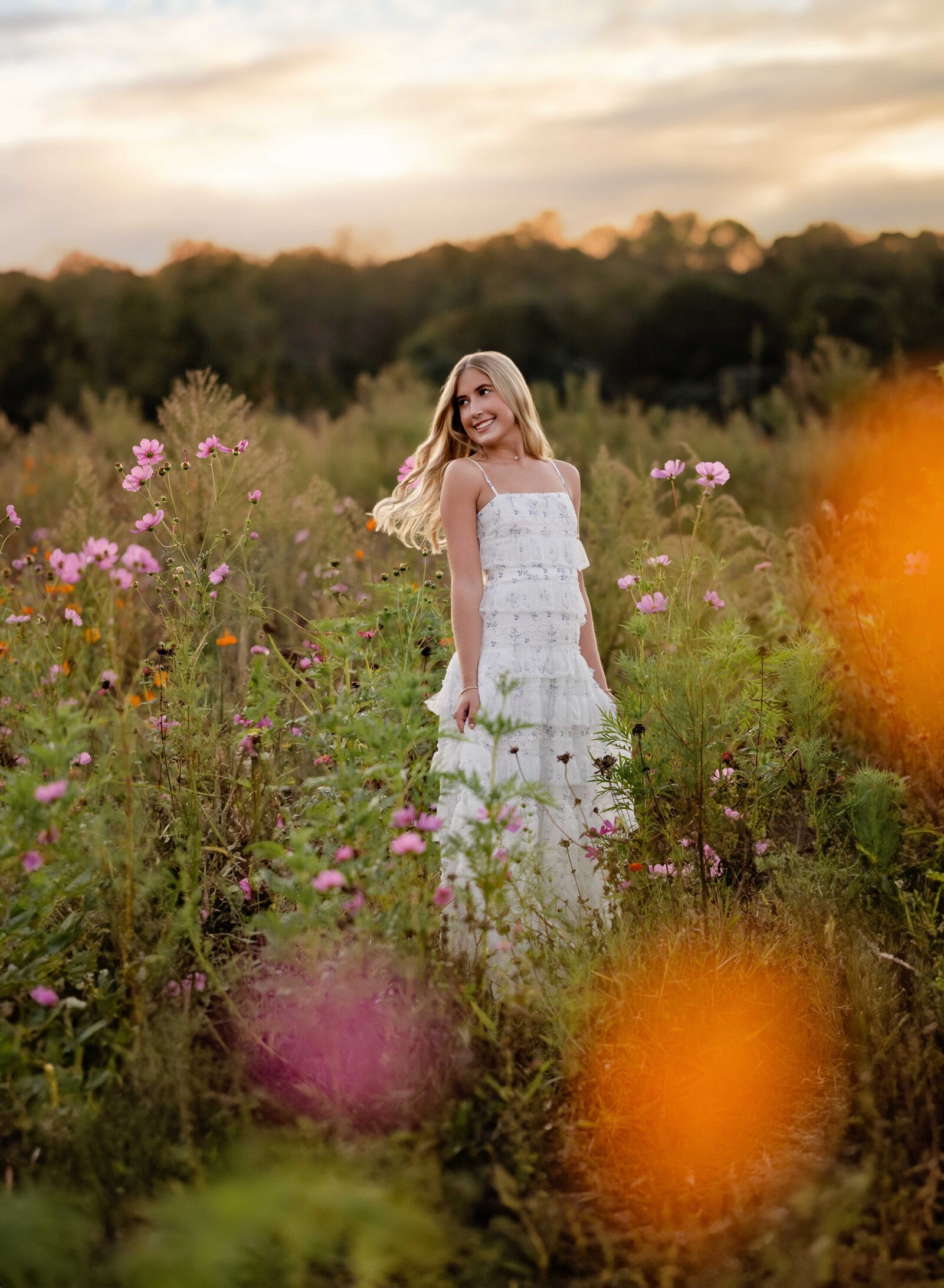Senior portrait of girl spinning around in wildflower field in GA. Senior graduation photos taken by Jenni Nikki Photography in Atlanta, GA