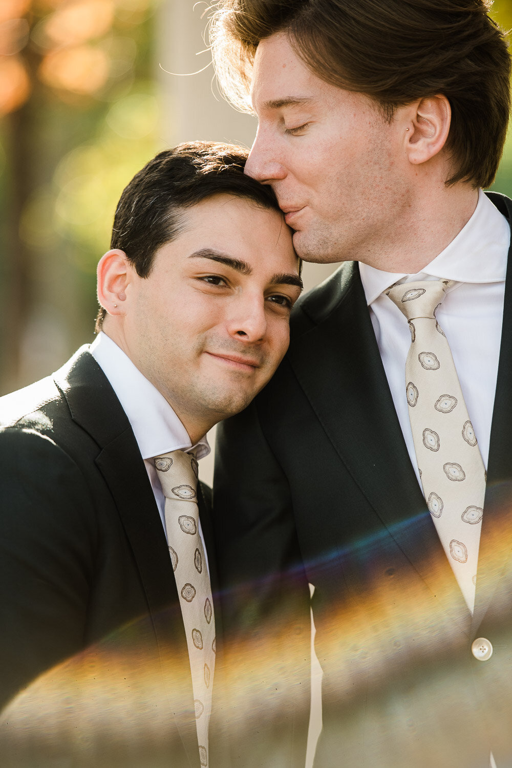 groom kiss groom on forehead closeup