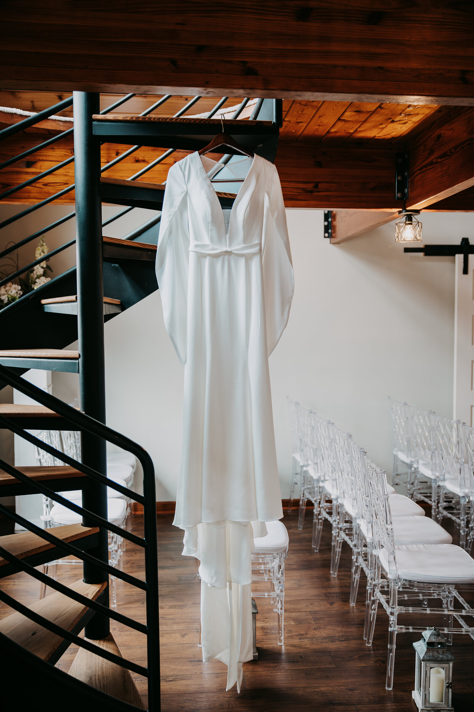 Wedding dress hanging from a spiral staircase at Kincaid Manor, creating an elegant and timeless bridal moment.