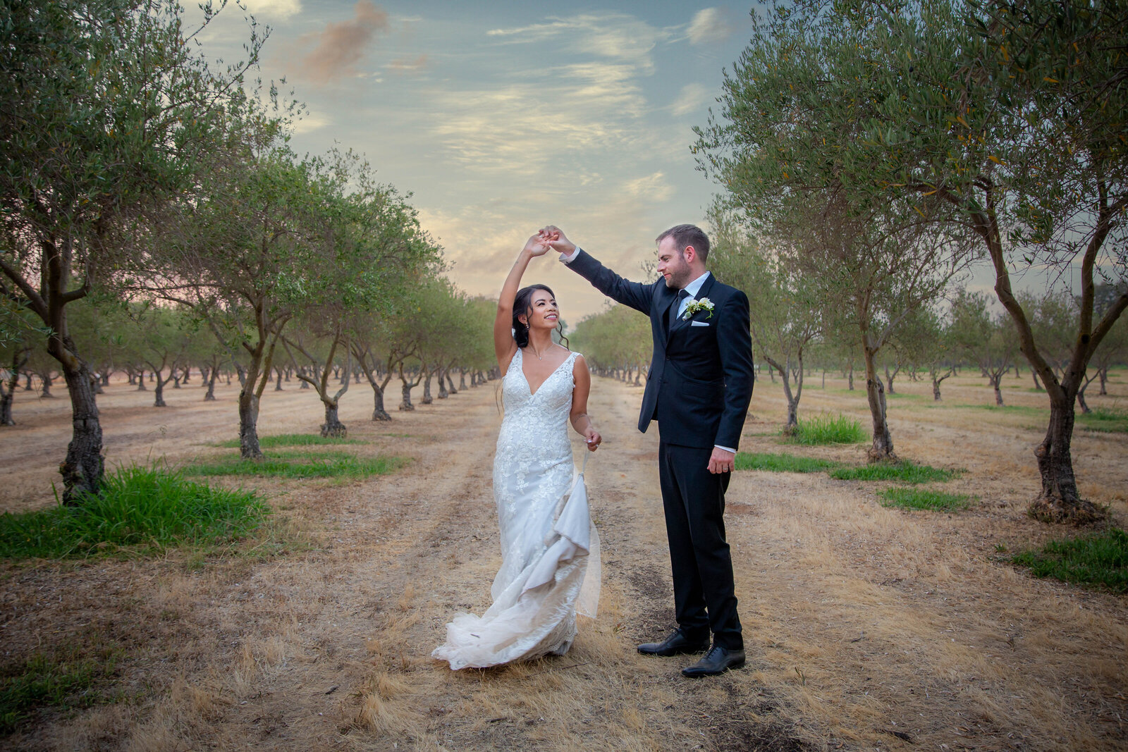 Sacramento groom twirls bride in the middle of a vineyard, and captured by sacramento wedding photographer, philippe studio pro.