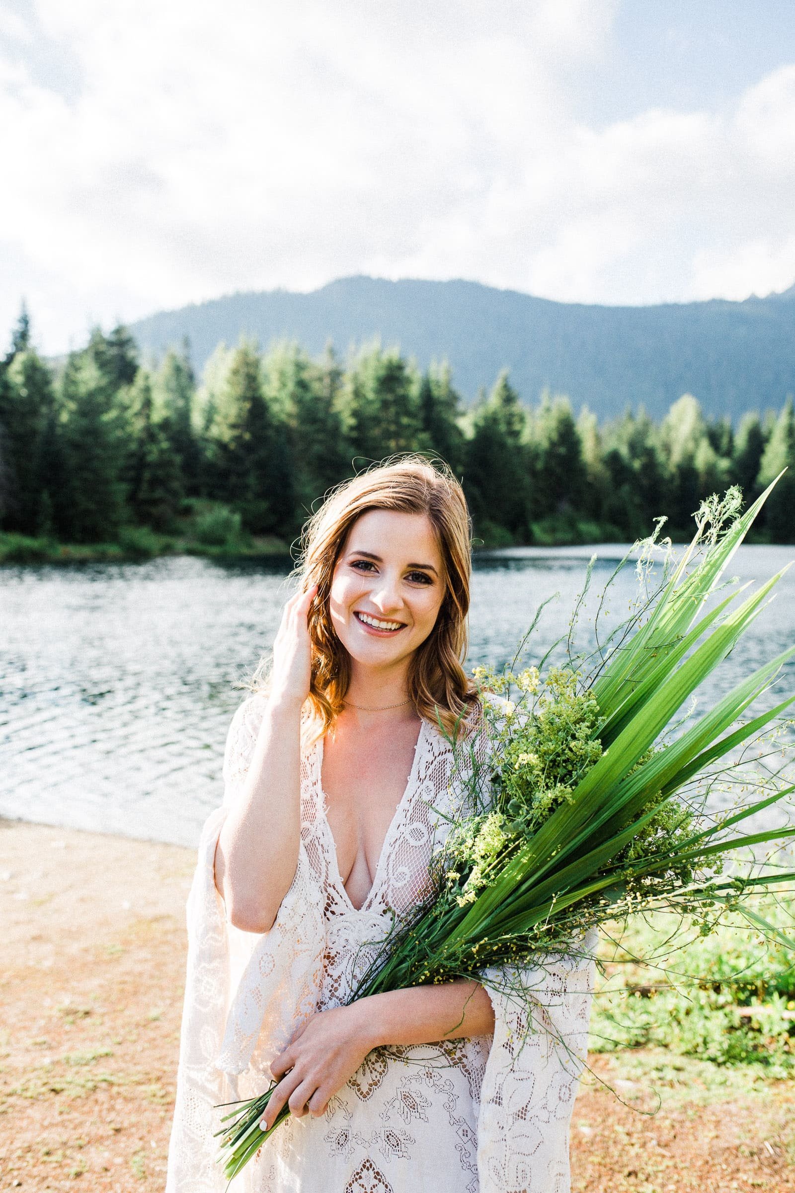 Bride holding greenery bouquet in PNW lakeside