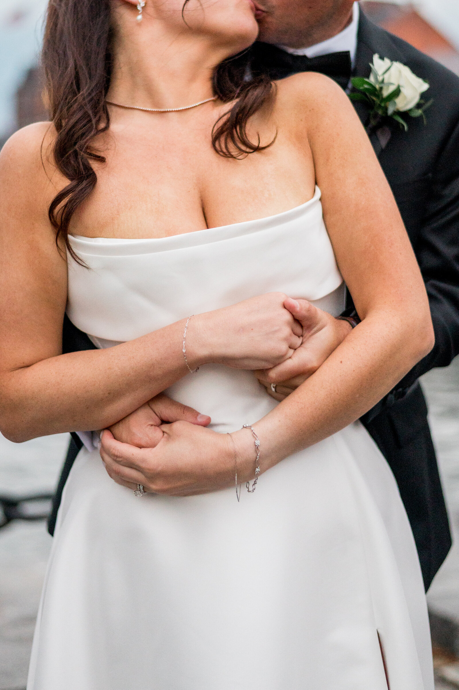 Romantic close-up of groom embracing bride during elegant Boston wedding — by Sarah Surette Photography.