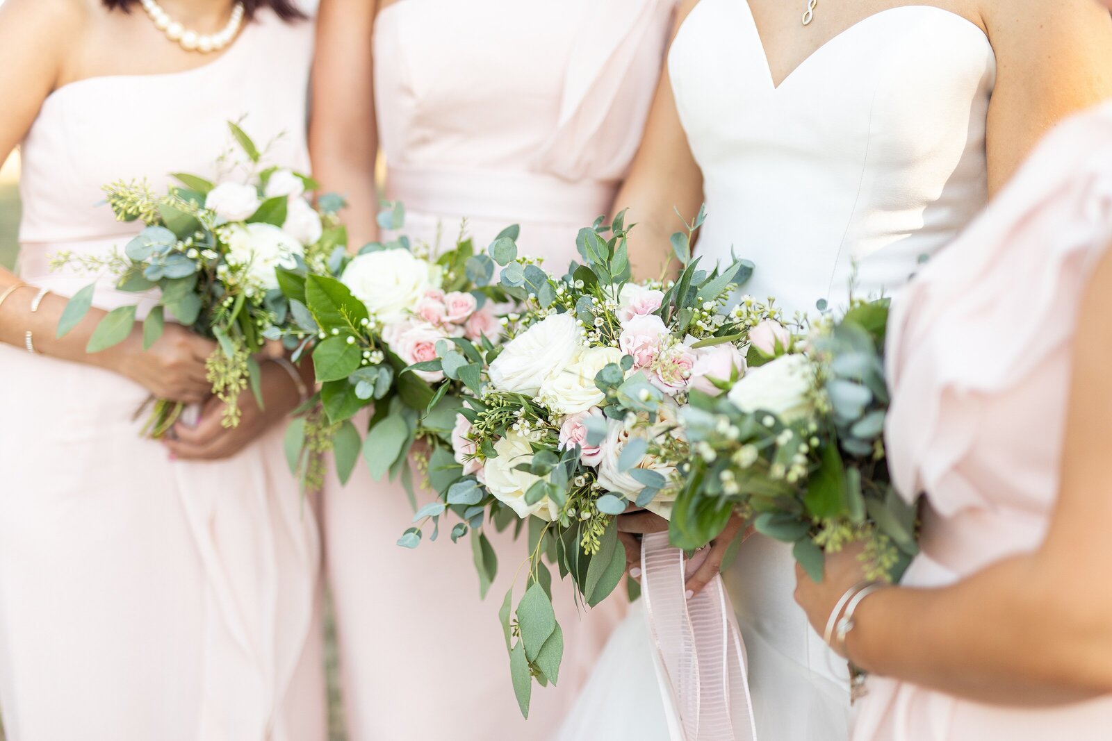 Bride and bridesmaids holding blush bouquets in Carlsbad.
