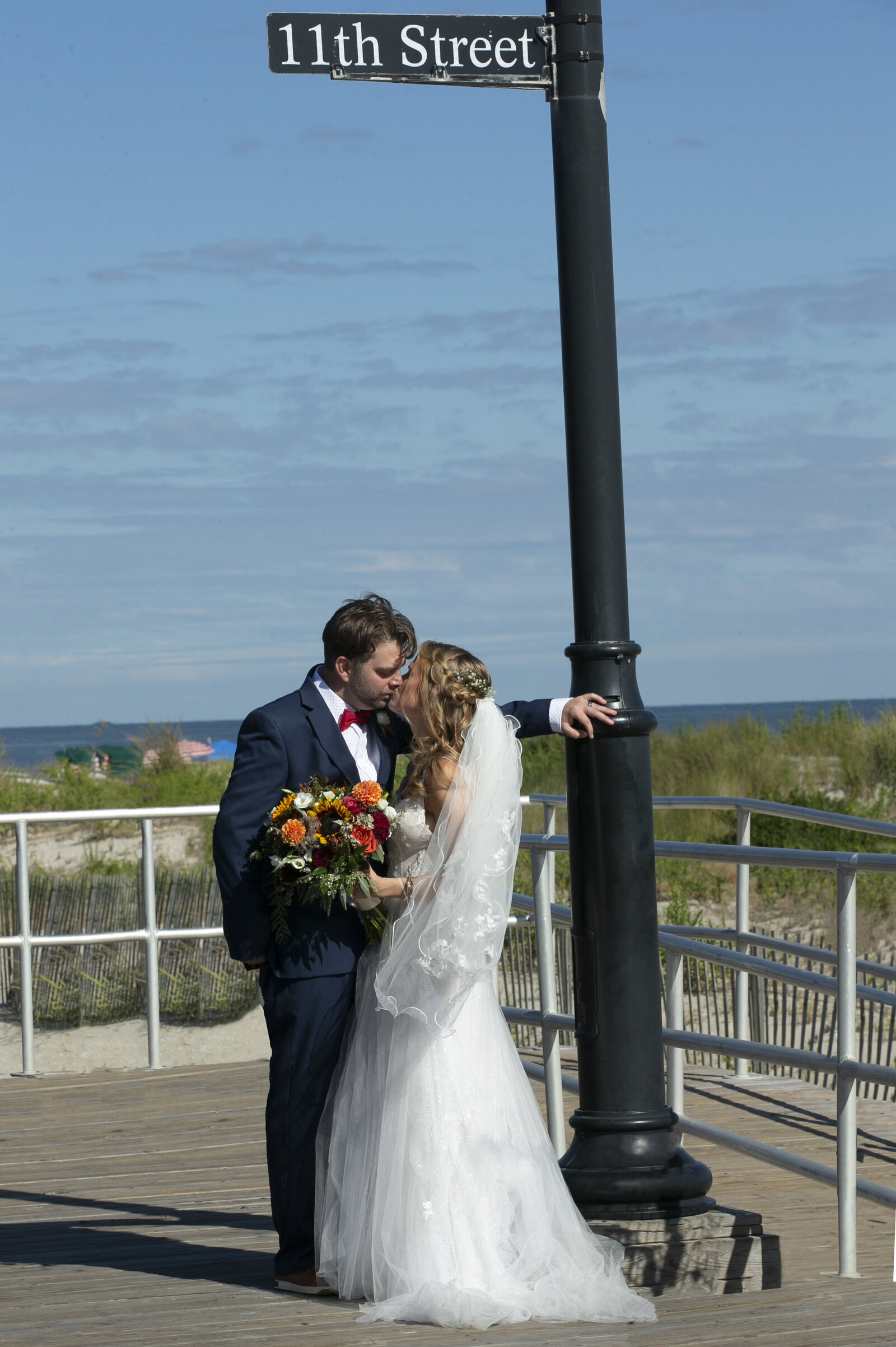 Bride and Groom kissing at 11th Street Boardwalk