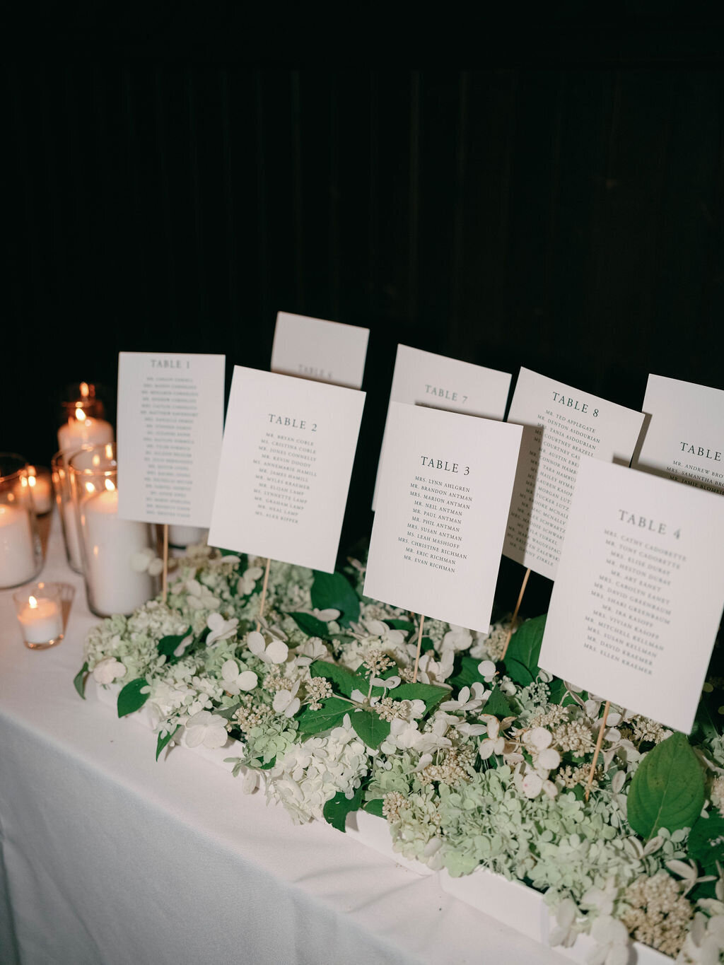 Escort card table meadow with white hydrangea blossoms.