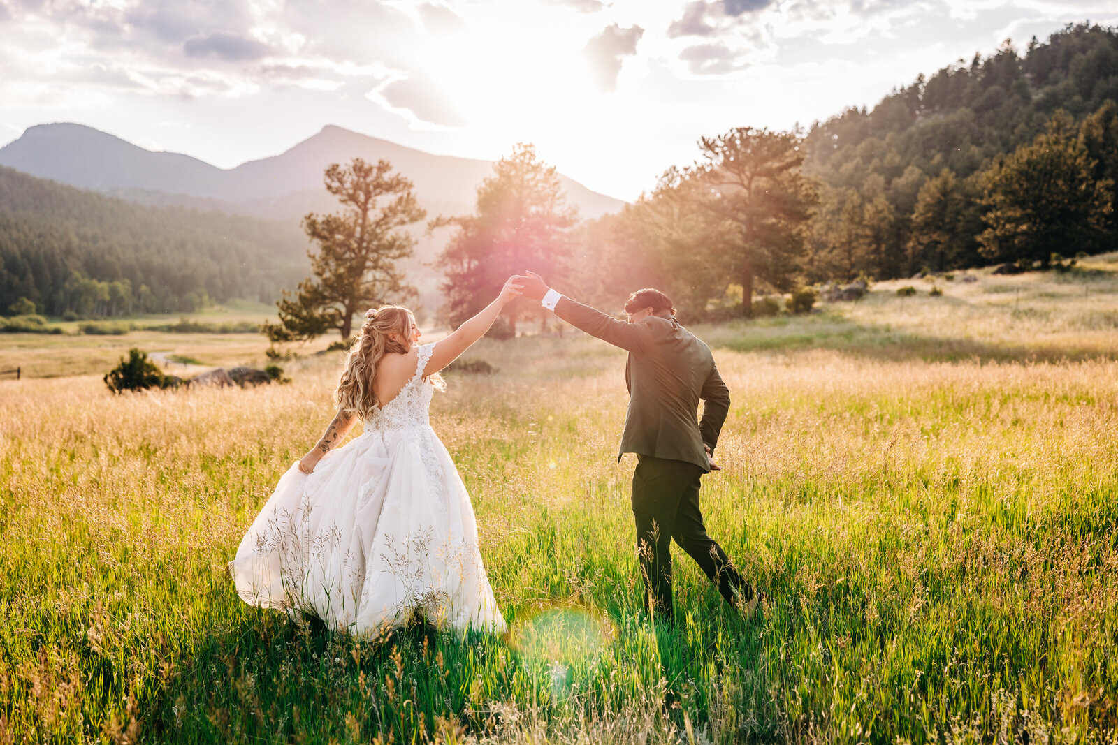 Wedding Photographer in Boulder Colorado captures bride and groom dancing in the grass during mountain elopement