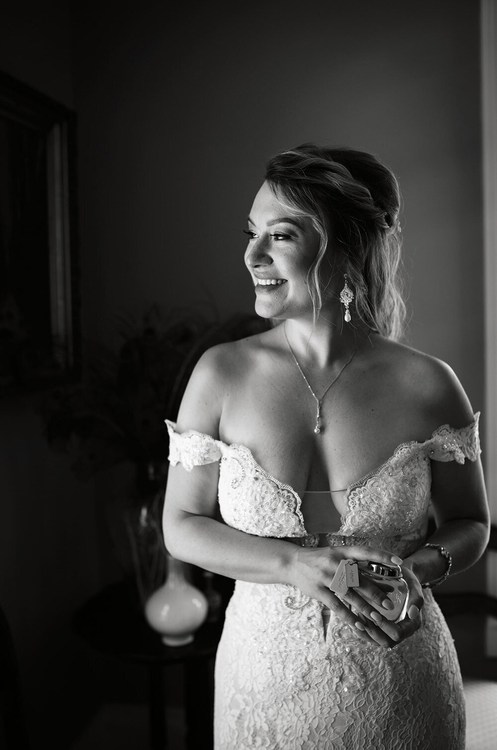 bride in black and white looks to her left, smiling