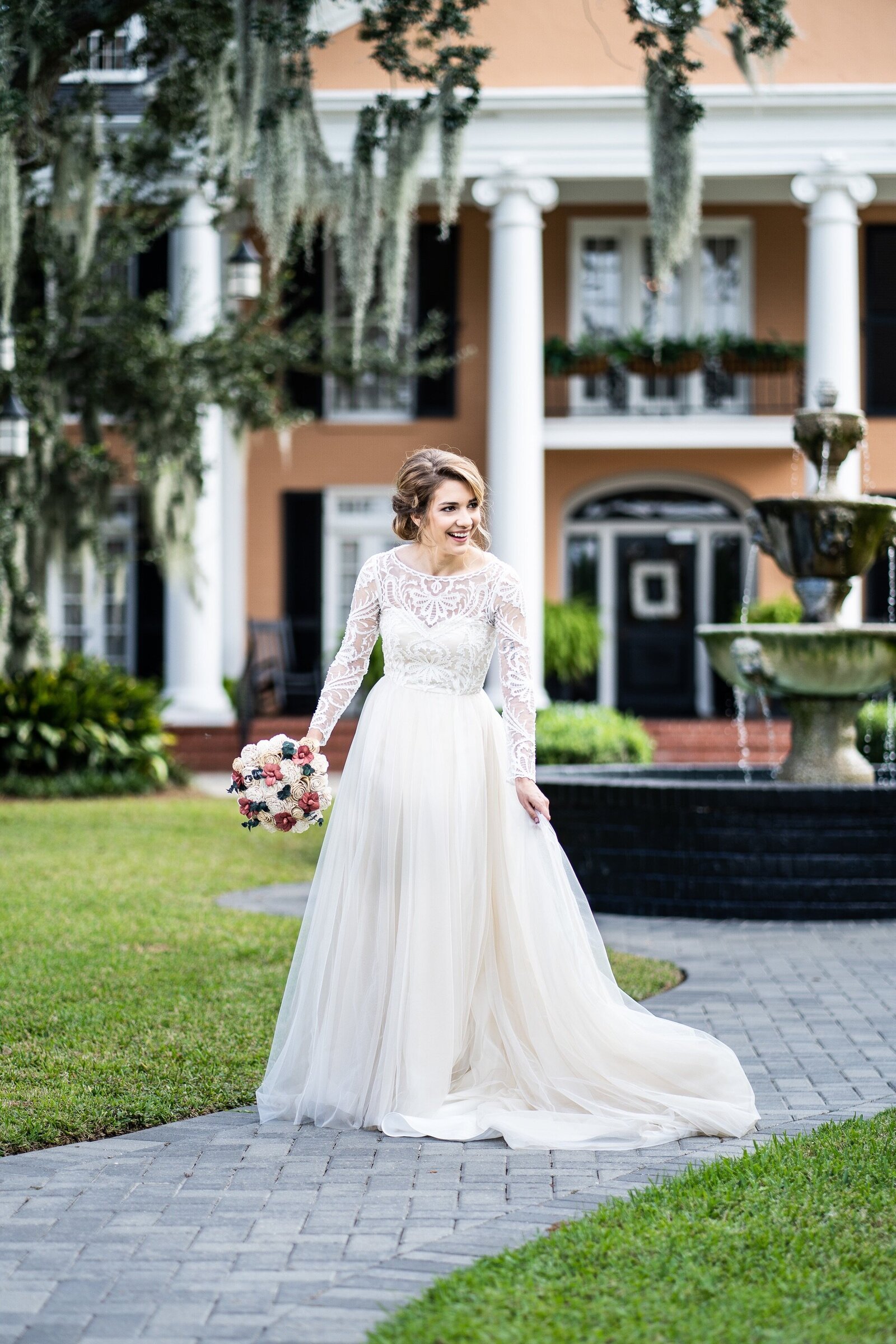 Bride laughing in front of Southern Oaks wedding venue in New Orleans