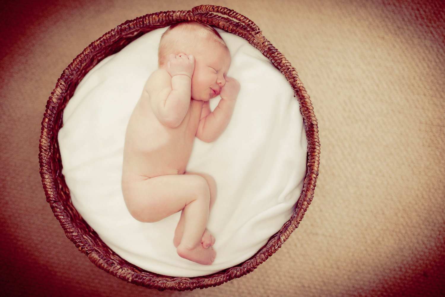 san diego newborn photography | newborn sleeping  in round basket with hands up