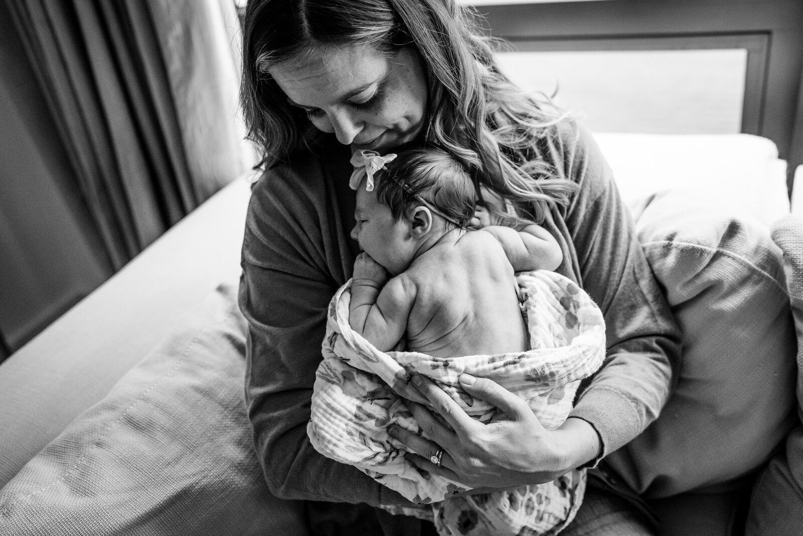 mom holds naked newborn to chest