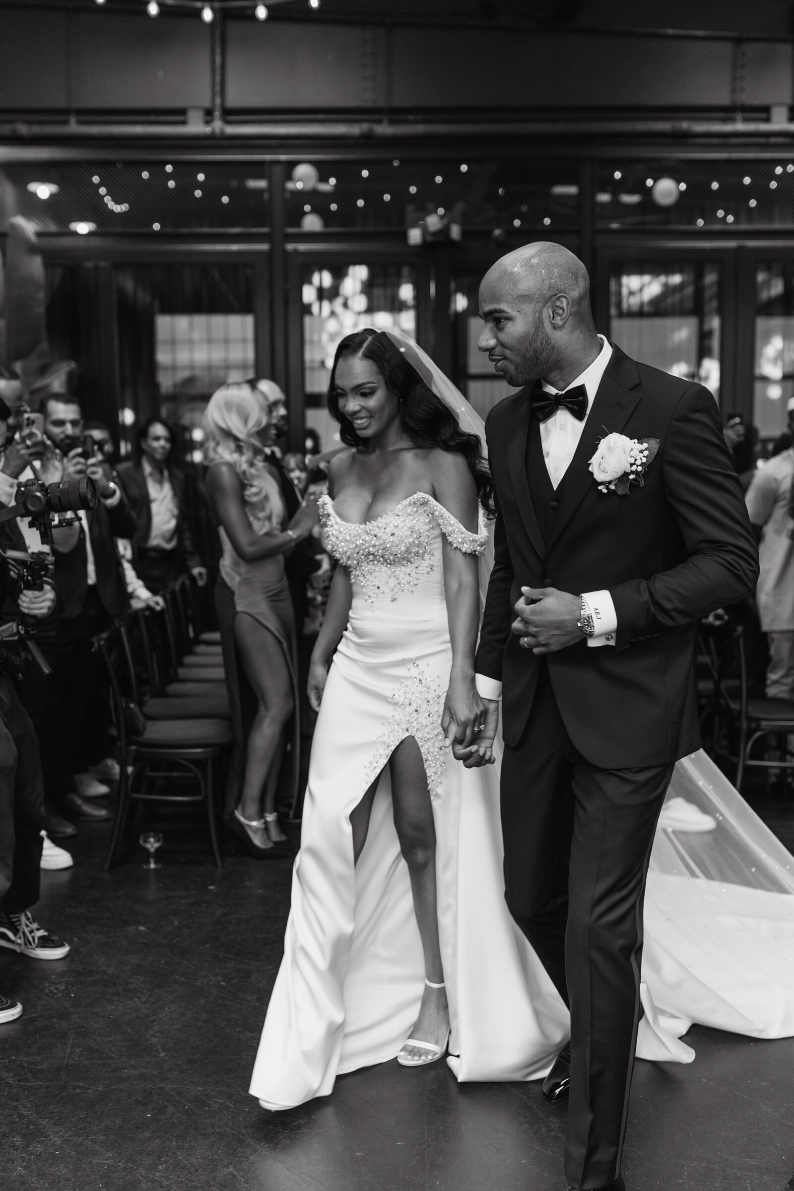 Black and white photo of bride and groom walking back down the aisle after being married at their black tie wedding | Emma LeeAnn Photography