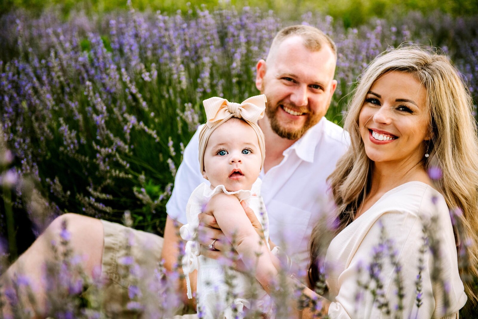 mom and dad with daughter in a flower field