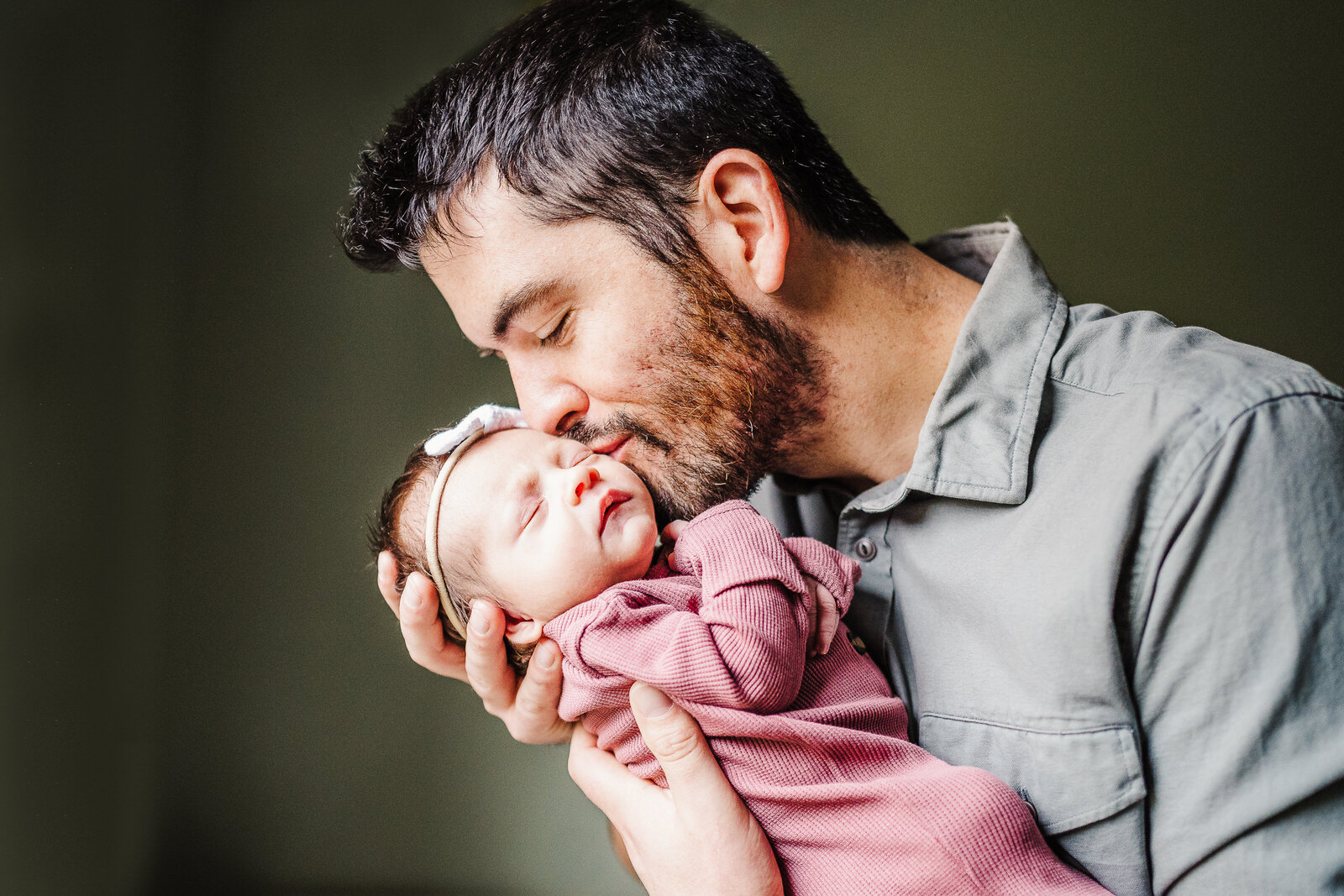 dad kisses new baby girl on cheek