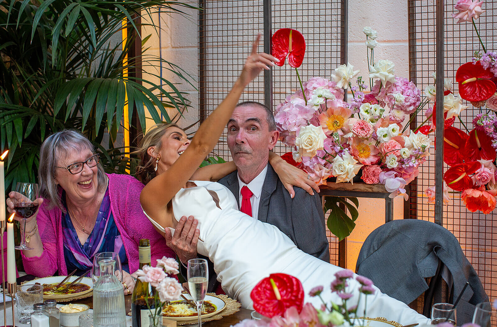 Bride sits in father in laws lap