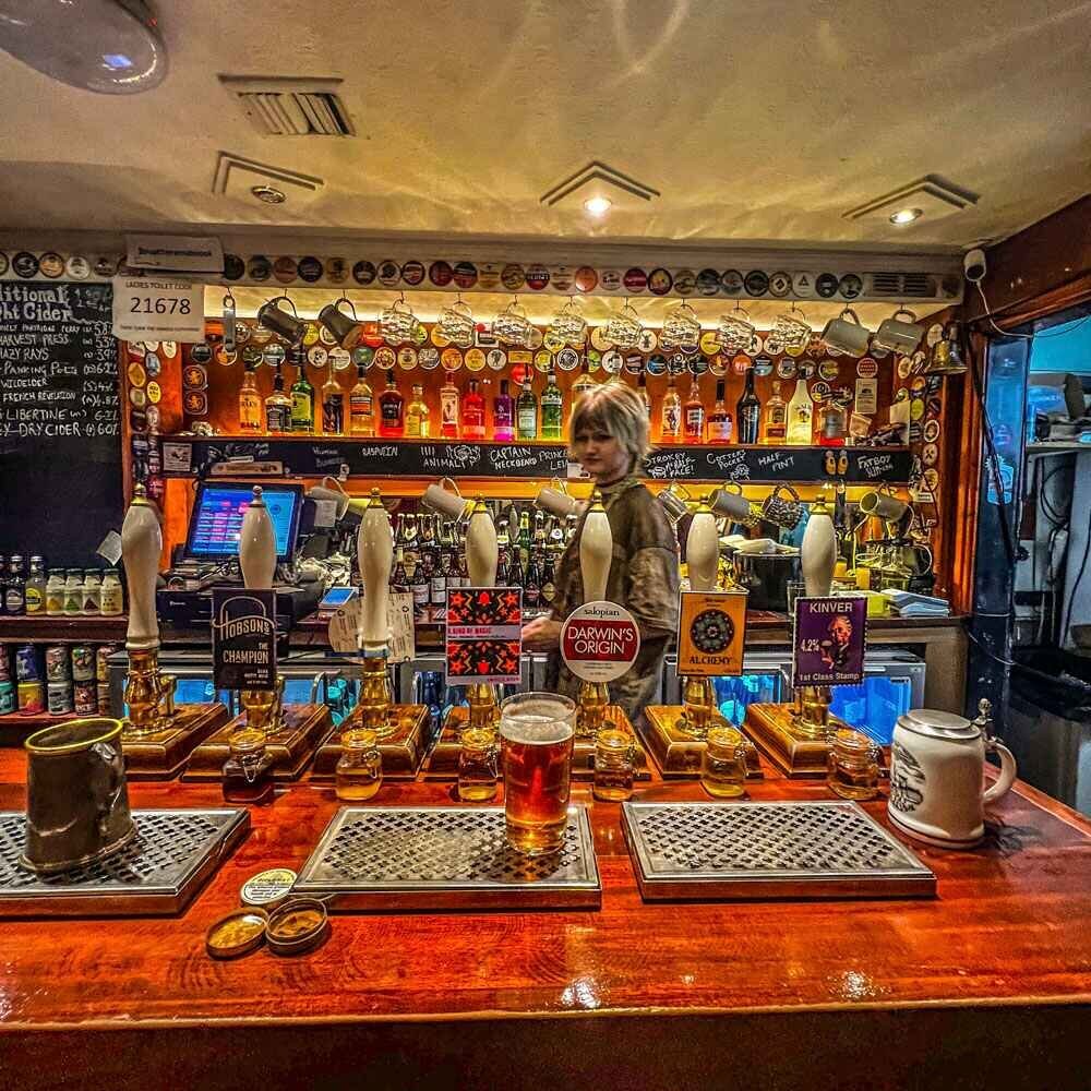 The bar in a pub with three pints on the counter