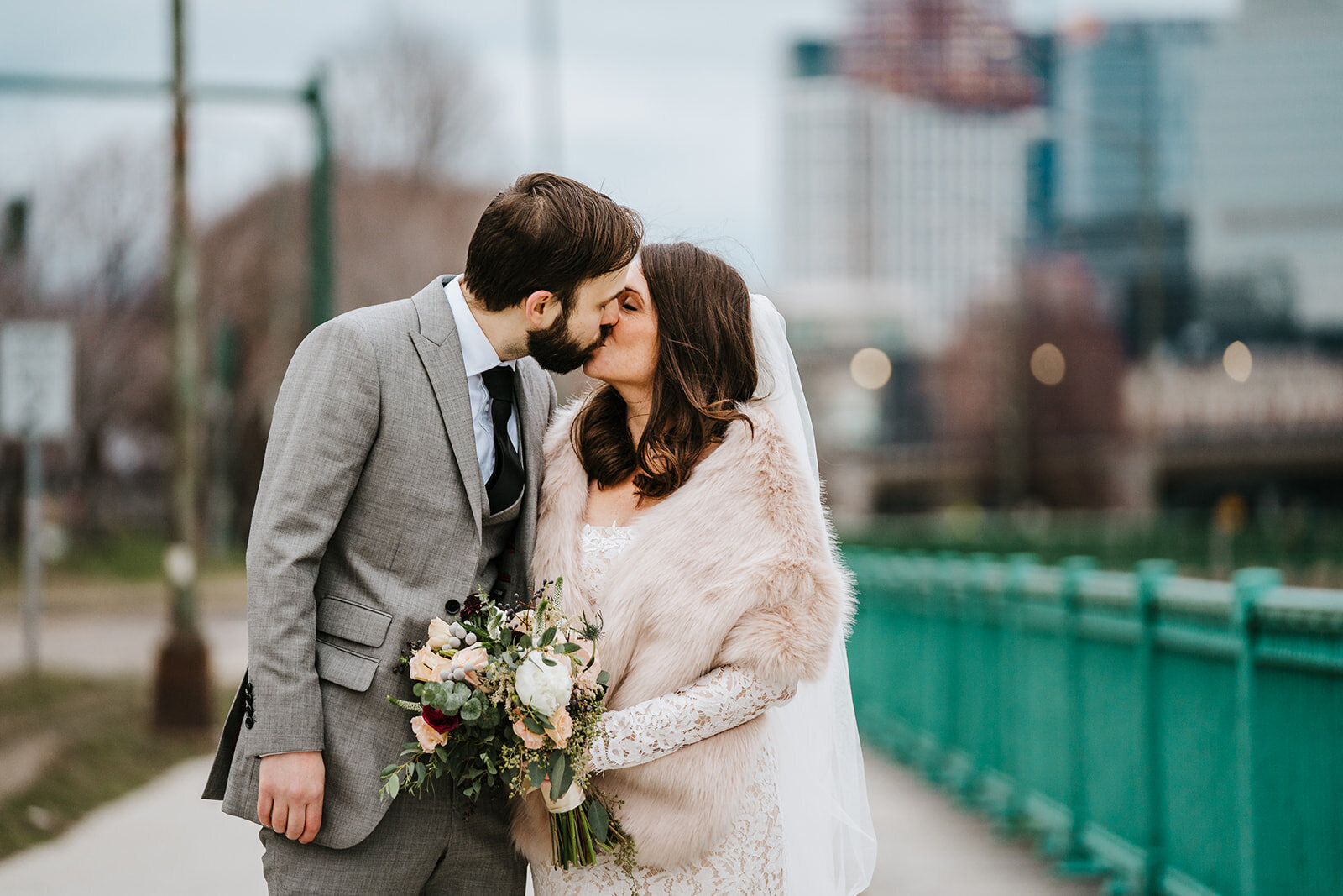 winter bride and groom kiss after city ceremony in boston