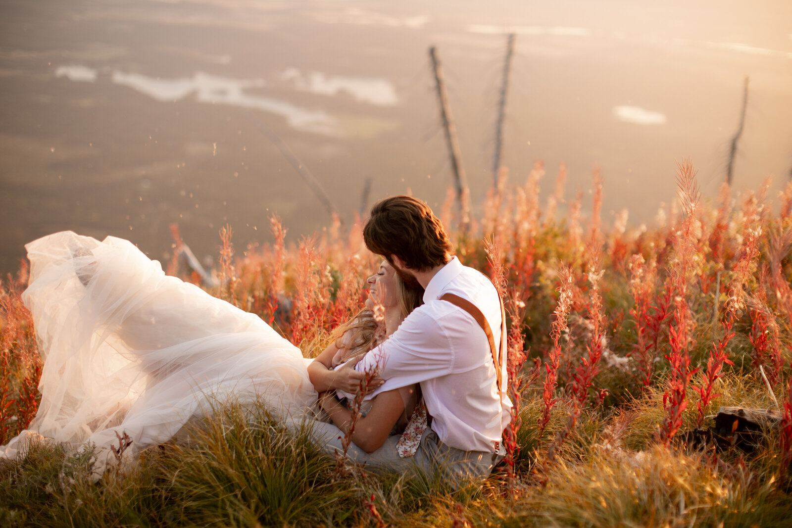 beautiful couple sitting on mountainside during sunset in montana