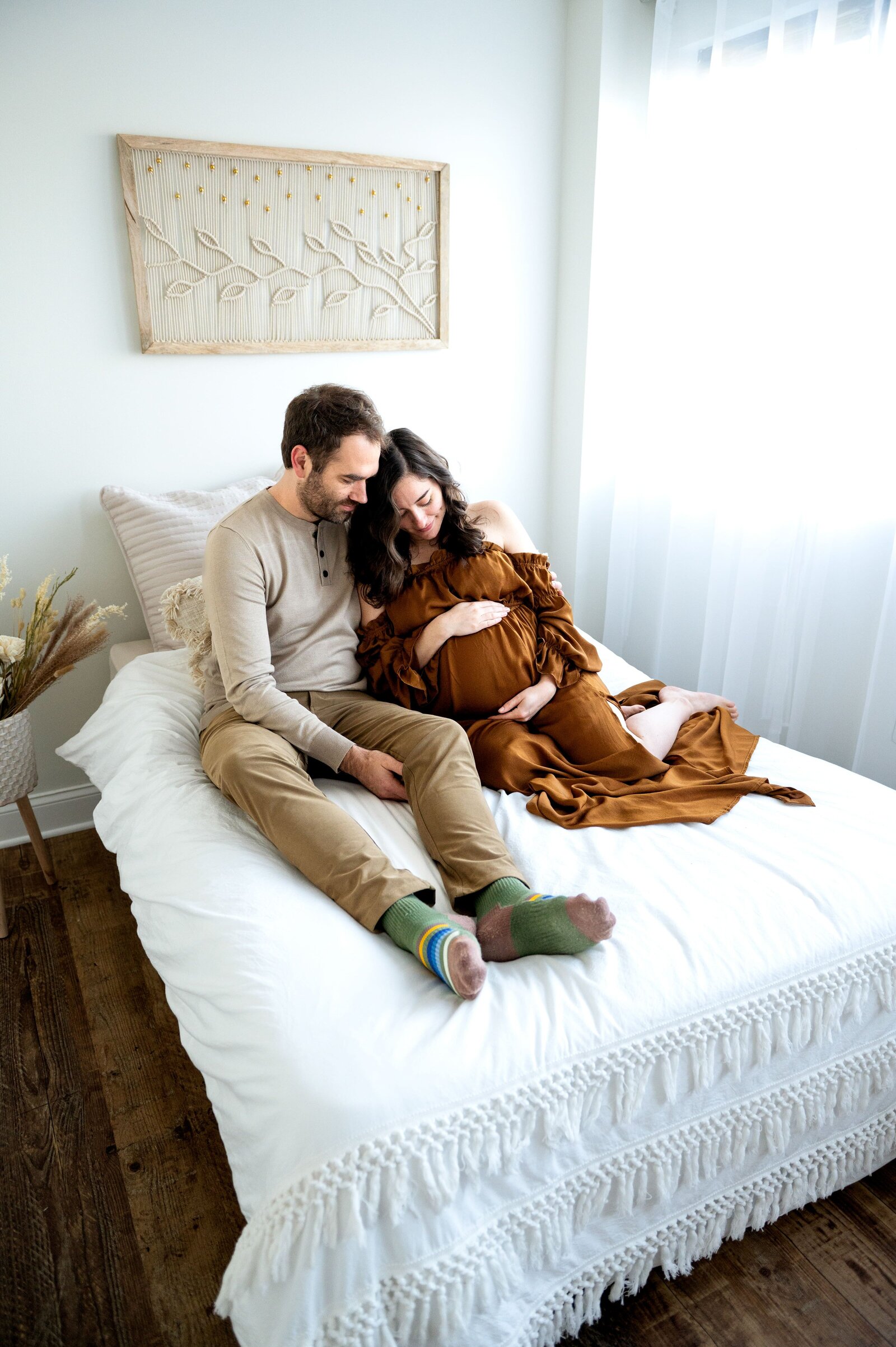 couple looking at moms belly in a bed