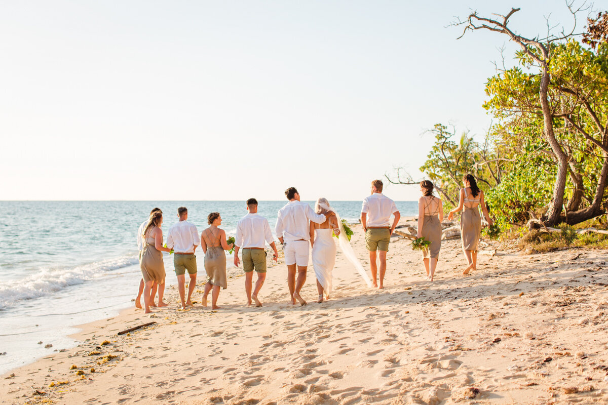 bridal party walking down the beach