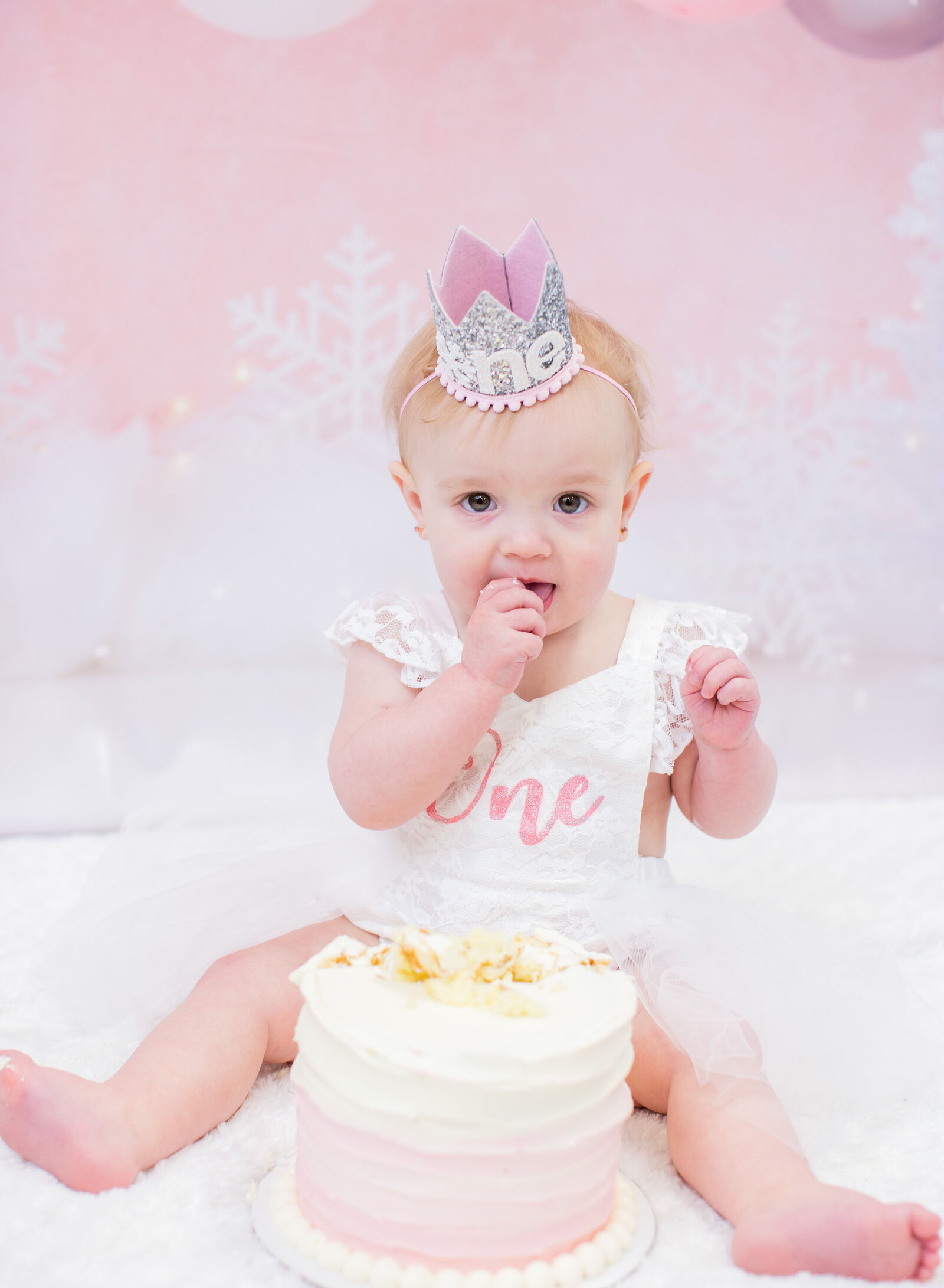 first birthday girl eating cake