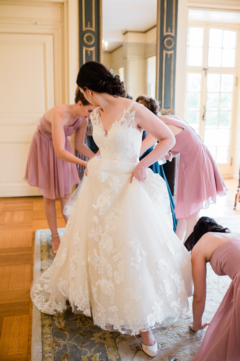 bridesmaids helping bride with dress