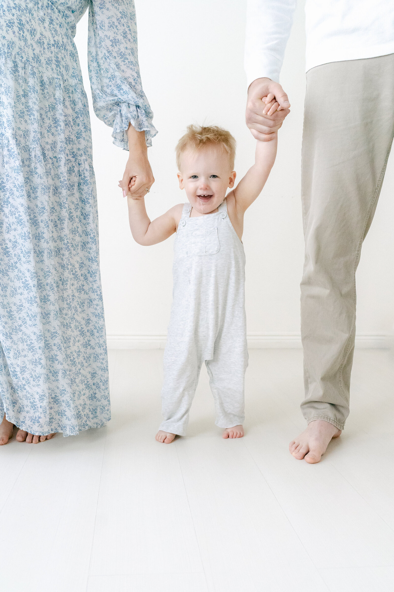 Mom and Dad holding toddlers hands